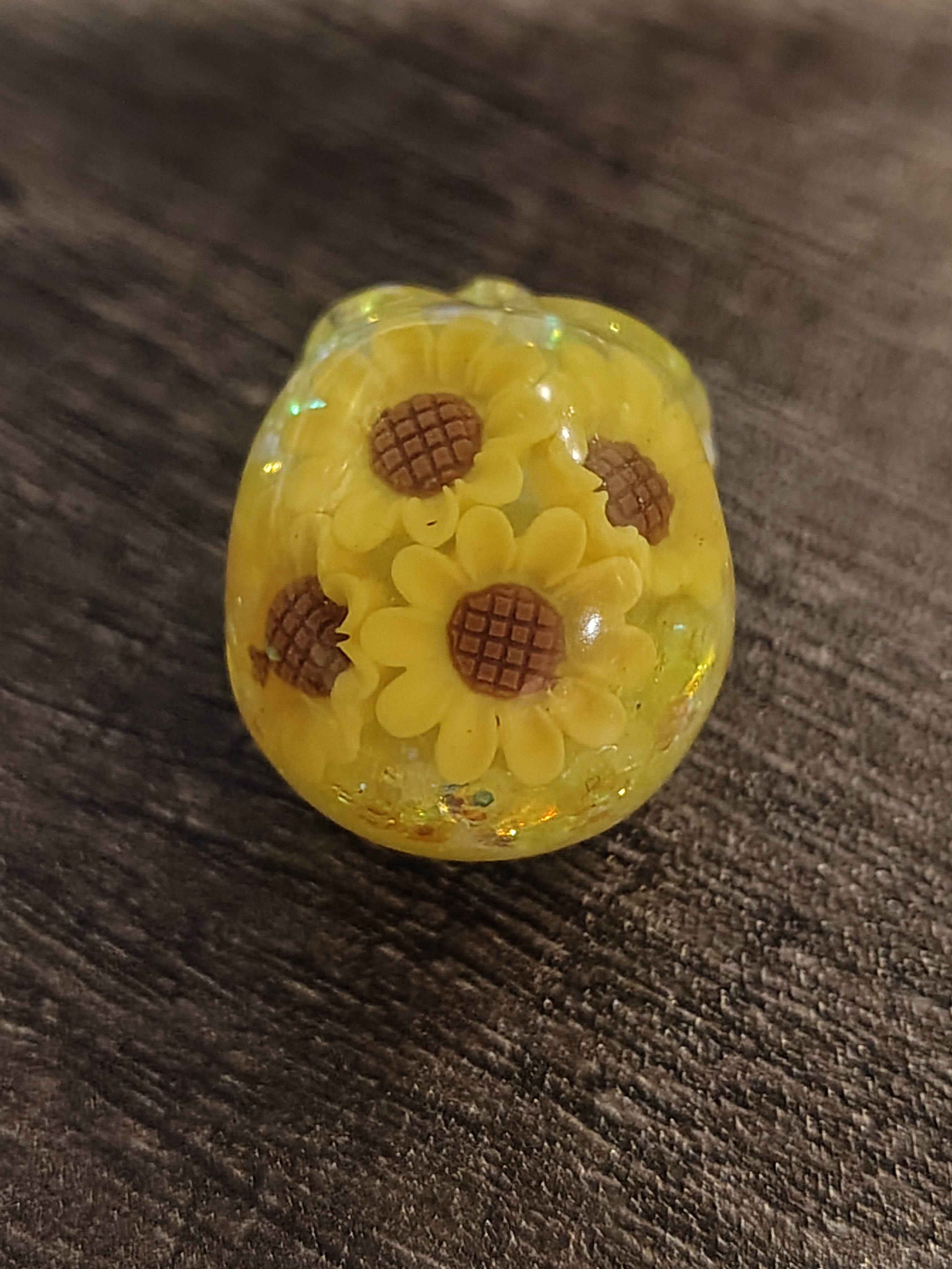 Yellow resin mini skull with sunflower charms - top view showing flower detail
