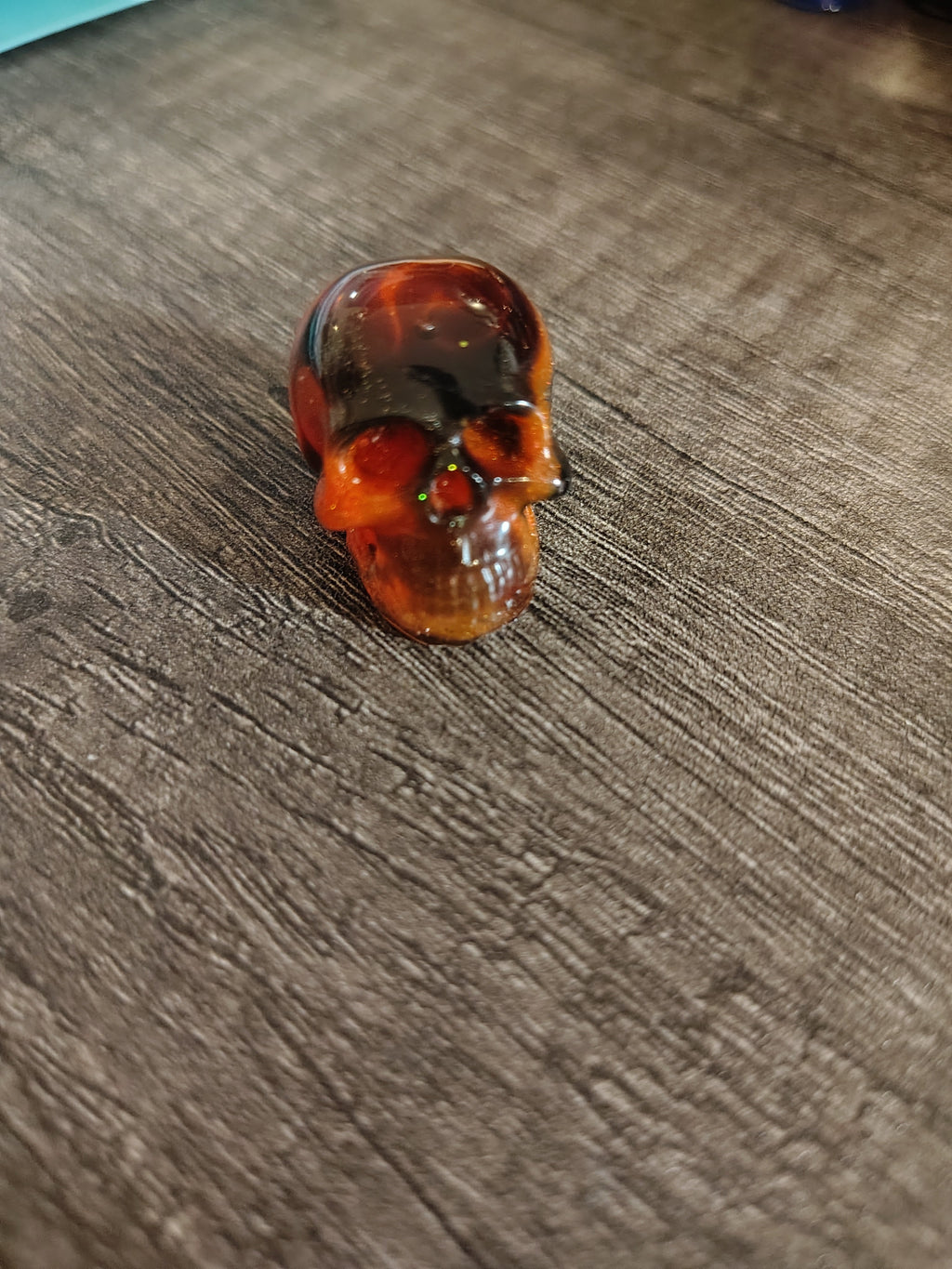 Amber orange and black swirl mini resin skull - front view