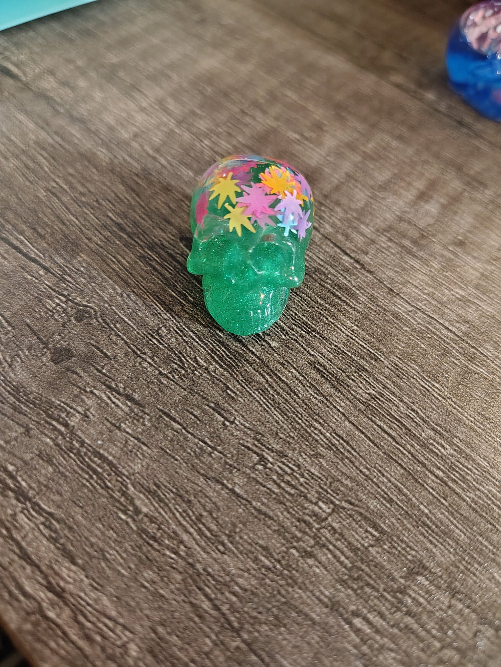 Green glitter mini skull with colorful maple leaf confetti crown - side view