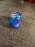 Clear blue and purple resin mini skull with white d6 dice inside - front view