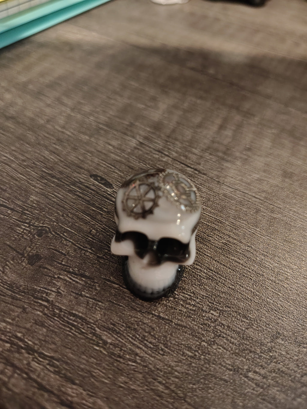 Black and white steampunk mini skull with bronze gears - side view