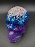 Large galaxy resin skull with white opal crown, blue holographic glitter, and deep purple jaw - side view