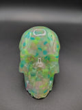 Medium clear resin skull packed with teal and green glow-in-the-dark Loomlight stones - front view