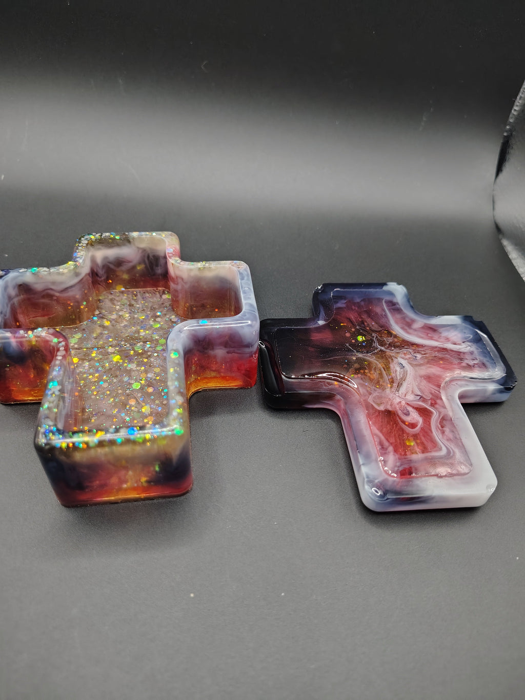 Cross-shaped resin trinket box with lid removed showing interior and gold glitter